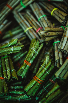High angle close up bundles of beedi cigarettes, tobacco wrapped in green leaves and tied with a string.,Goa