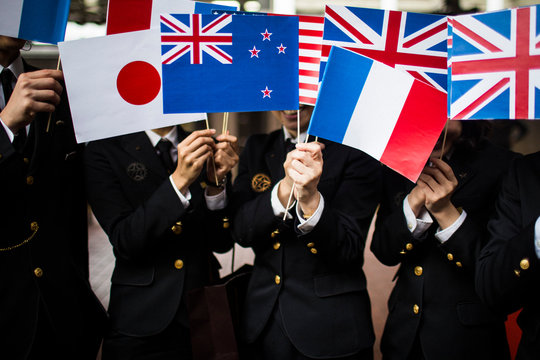 Close up of people in uniform waving small national flags. ,Hakata