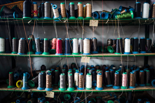 Close up of shelves of colorful thread for sewing shoe soles in a factory.