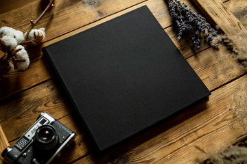 Black book on a wooden table, view from top