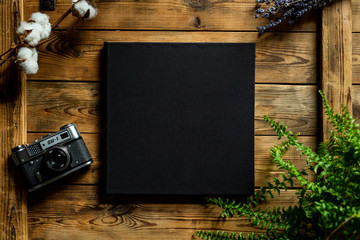 Black book on a wooden table, view from top, old camera FED 5