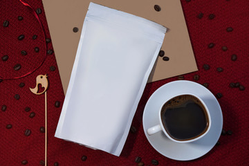 Template paper packaging on a background of delicious black coffee and beans. Mocap for branding your product on the package. Stock photo for design
