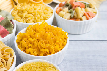Set different of types and shapes of dry Italian  of pasta on a wooden table.