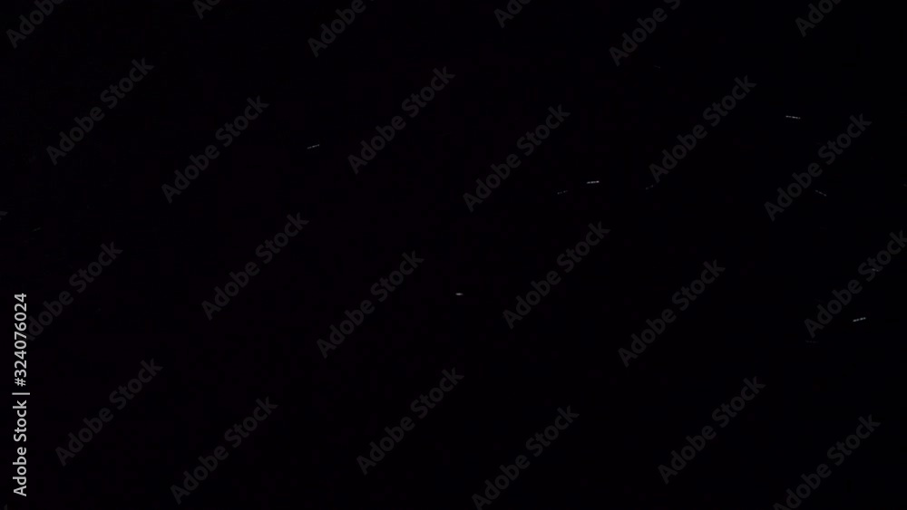 Poster real dust particles floating in front of a black background.