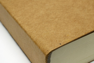 Macro of blank notebook corner with cardboard hardcover isolated on white as template for presentation, showcase design logo, embossing etc.