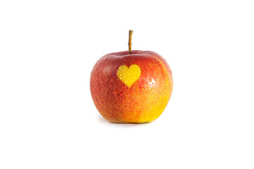 Heart shaped symbol on the wet skin of an apple with drops seen. Naturally developed heart shape on an apple due to lack of light on that certain part of an apple. Concept of healthy living.
