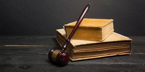 Law concept - Open law book with a wooden judges gavel on table in a courtroom or law enforcement office isolated on white background. Copy space for text.