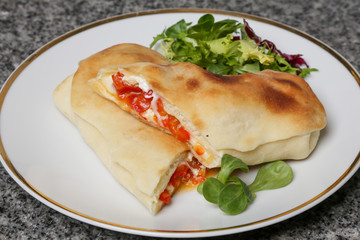 Italian appetizer bread stuffed with paprika and cheese,  simple savory stuffed bread on a plate