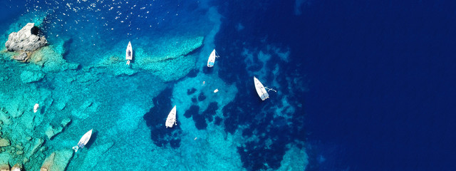 Aerial drone ultra wide photo of sail boat docked in tropical exotic bay with turquoise clear sea