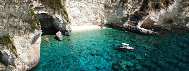 Aerial drone ultra wide photo of breathtaking turquoise exotic bay of blue lagoon in island of Paxos visited by sail boats, Ionian, Greece