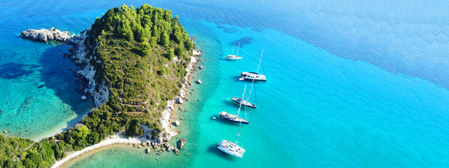 Naklejka premium Aerial drone ultra wide photo of breathtaking turquoise exotic bay of blue lagoon in island of Paxos visited by sail boats, Ionian, Greece