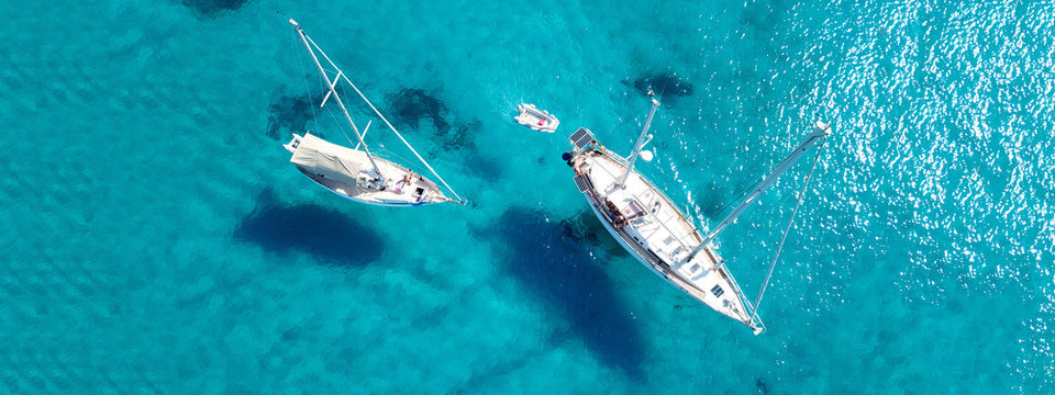 Aerial drone ultra wide photo of sail boat docked in tropical exotic bay with turquoise clear sea