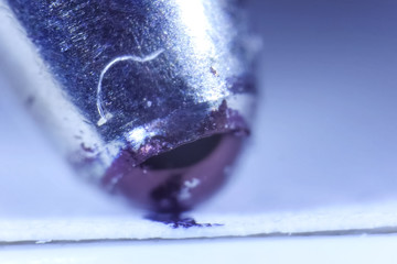 The end of a ballpoint pen writing on paper. Ballpoint pen