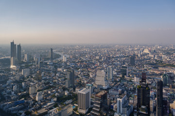 Aerial view of skyline and cityscape of Bangkok, urban buildings along Chao Phraya river, with background of twilight sky before sunset with air pollution of pm 2.5 dust, from Mahanakorn Building.