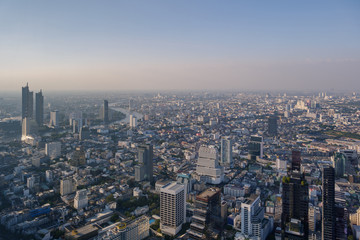 Obraz premium Aerial view of skyline and cityscape of Bangkok, urban buildings along Chao Phraya river, with background of twilight sky before sunset with air pollution of pm 2.5 dust, from Mahanakorn Building.