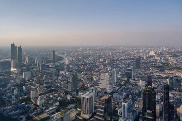 Poster Aerial view of skyline and cityscape of Bangkok, urban buildings along Chao Phraya river, with background of twilight sky before sunset with air pollution of pm 2.5 dust, from Mahanakorn Building. © Peeradontax