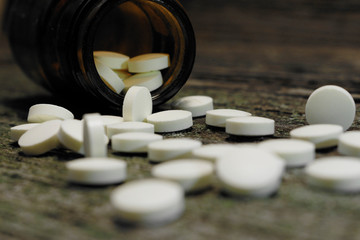 tabletki na stole z pojemnikiem na lekarstwa
