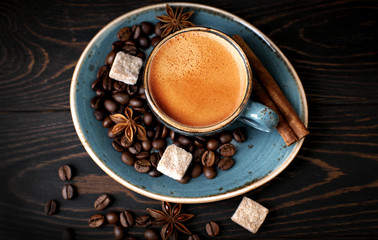 Coffee Cup on a wooden background, rustic, espresso with cinnamon sticks, star anise, blue coffee Cup, coffee beans on an old Board, rustic, dark, flavor, natural, drink, sugar chunks, top view, craft