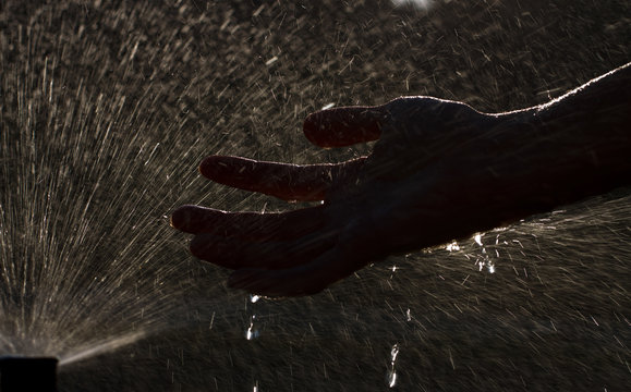 Agua cayendo en la mano oscura