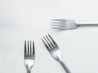 Three Forks on a Rustic Board Painted with White Background