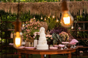 Fototapeta na wymiar Wedding Setup. Cake table with sweet, decoration and flowers 
