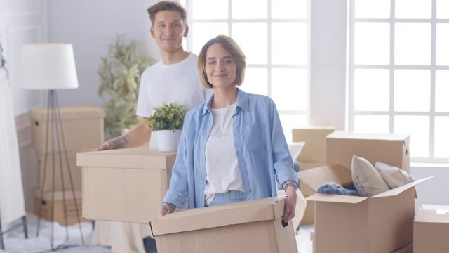 A young woman moving in new home, holding a box