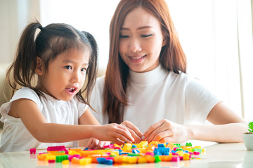 Asian beautiful Mother and her Daughter playing toy together in living room at their home in a relaxing day, Asian family Concept