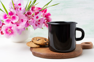 Black campfire enamel mug mockup with pink clarkia flowers