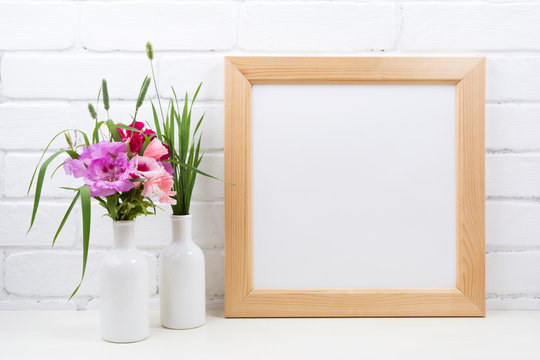 Wooden square frame mockup with pink godetia flowers