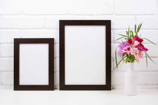 Two black brown poster frame mockup with pink clarkia flowers © TasiPas