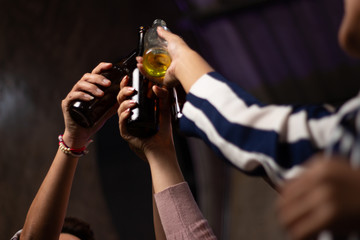 group of people clinking glass bottles of beer party after work