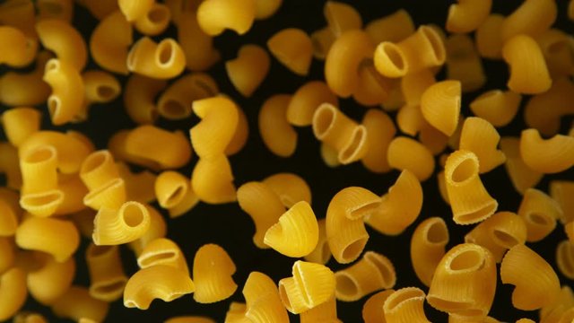 Super slow motion of flying uncooked italian pasta on black background. Filmed on high speed cinema camera, 1000 fps.