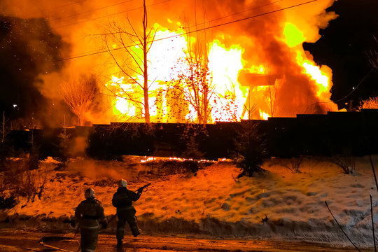 house is burning, a house fire in a village, firefighters exting