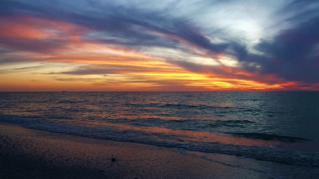 Beautiful sunset over the Gulf of Mexico with waves gently lapping up on St. Pete Beach, Florida.
