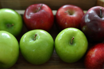 red and green apple fruit in harvest wood basket