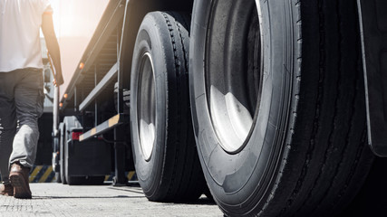 Closeup a truck wheels and a truck driver holding clipboard inspecting safety vehicle maintenance...