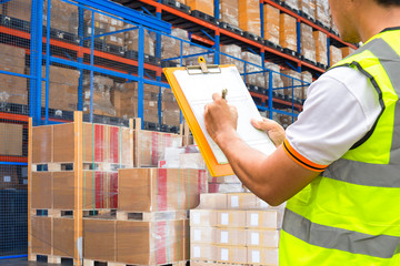 Warehouse worker courier hand holding clipboard inspecting details checklist storage of goods,...
