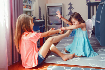 Two little mad angry girls sisters having fight at home. Friends girls can not share toy. Lifestyle...