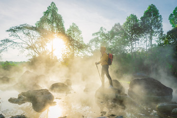 Traveler and Morning steam over hot spring at Chae Son National Park, Thailand.