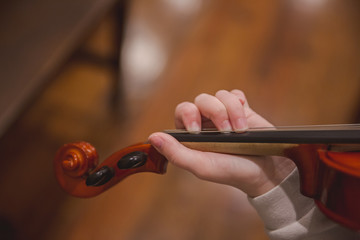 Fototapeta na wymiar Girl practicing violin at home in pajamas