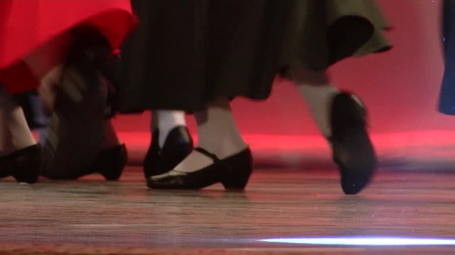 Women in black shoes and red skirts dance