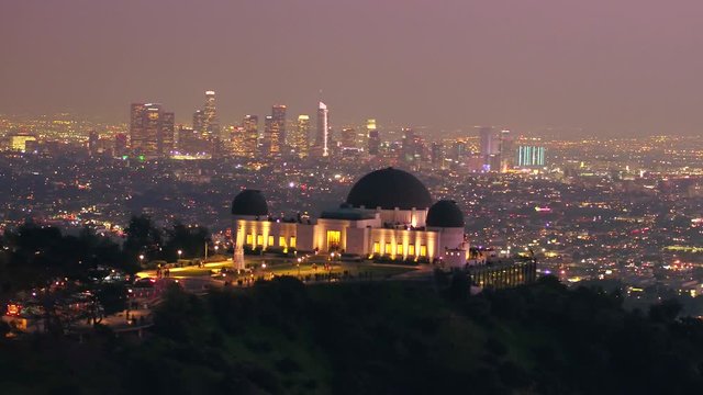 Aerial, tracking, drone shot, of the Griffith Observatory, on Mount Hollywood, at dusk, in Los Angeles, California, USA