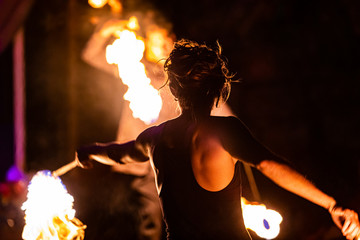 Professional fire dancers put on a show during event celebrating nature and peace, swinging rope...