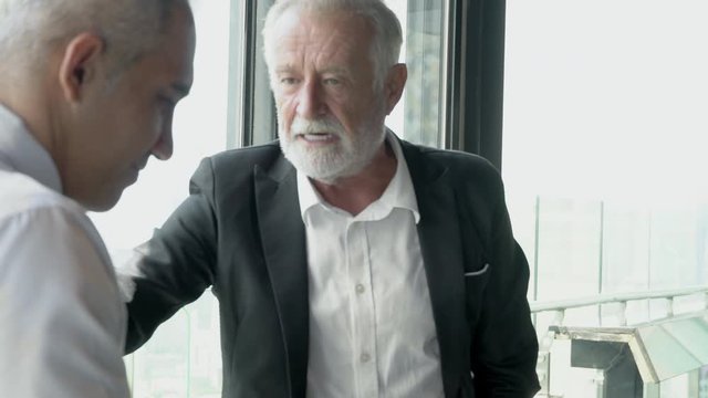 Senior businessman greeting shaking hand and discussion with partnership about work at office, executive meeting and shaking handshake for congratulation and talking for success, business concept.