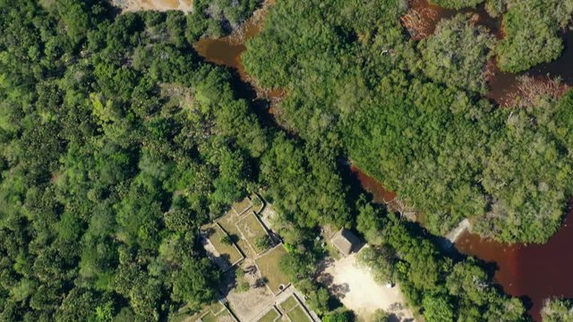 Aerial, tilt up, drone shot over the Xcambo ruins and the laguna Rosada lake, towards the Gulf of Mexico, on a sunny day, in Yucatan
