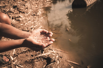 The boy waiting for drinking water to live through this drought, Concept drought and crisis environment.