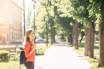 girl with a backpack strolling around the city