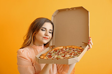 Portrait of beautiful young woman with tasty pizza on color background