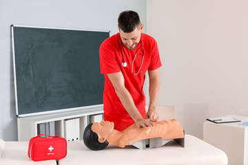 Instructor demonstrating CPR on mannequin at first aid training course