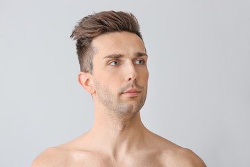 Fototapeta premium Handsome young man on light background. Plastic surgery concept